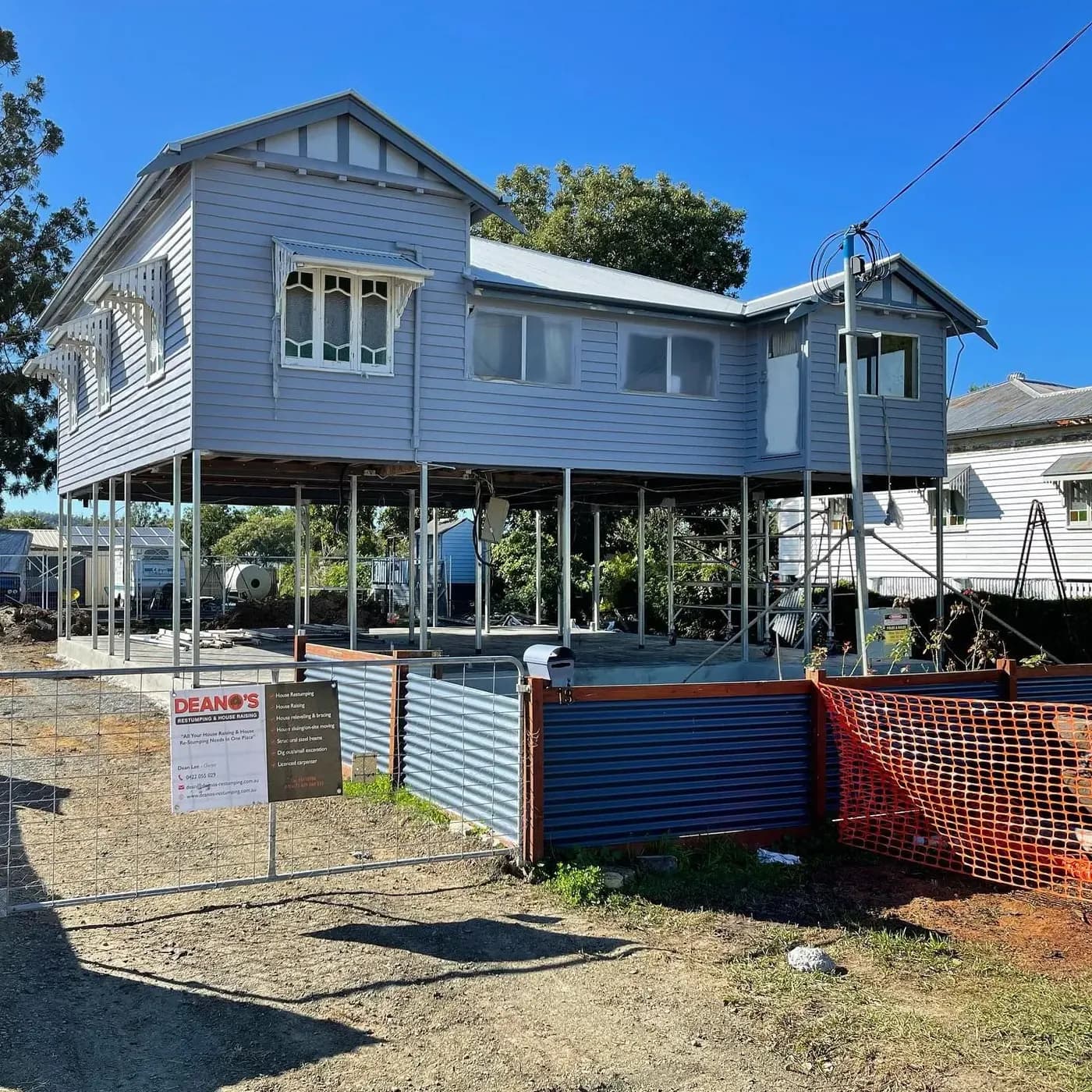 Raised weatherboard home supported on new posts and bracing