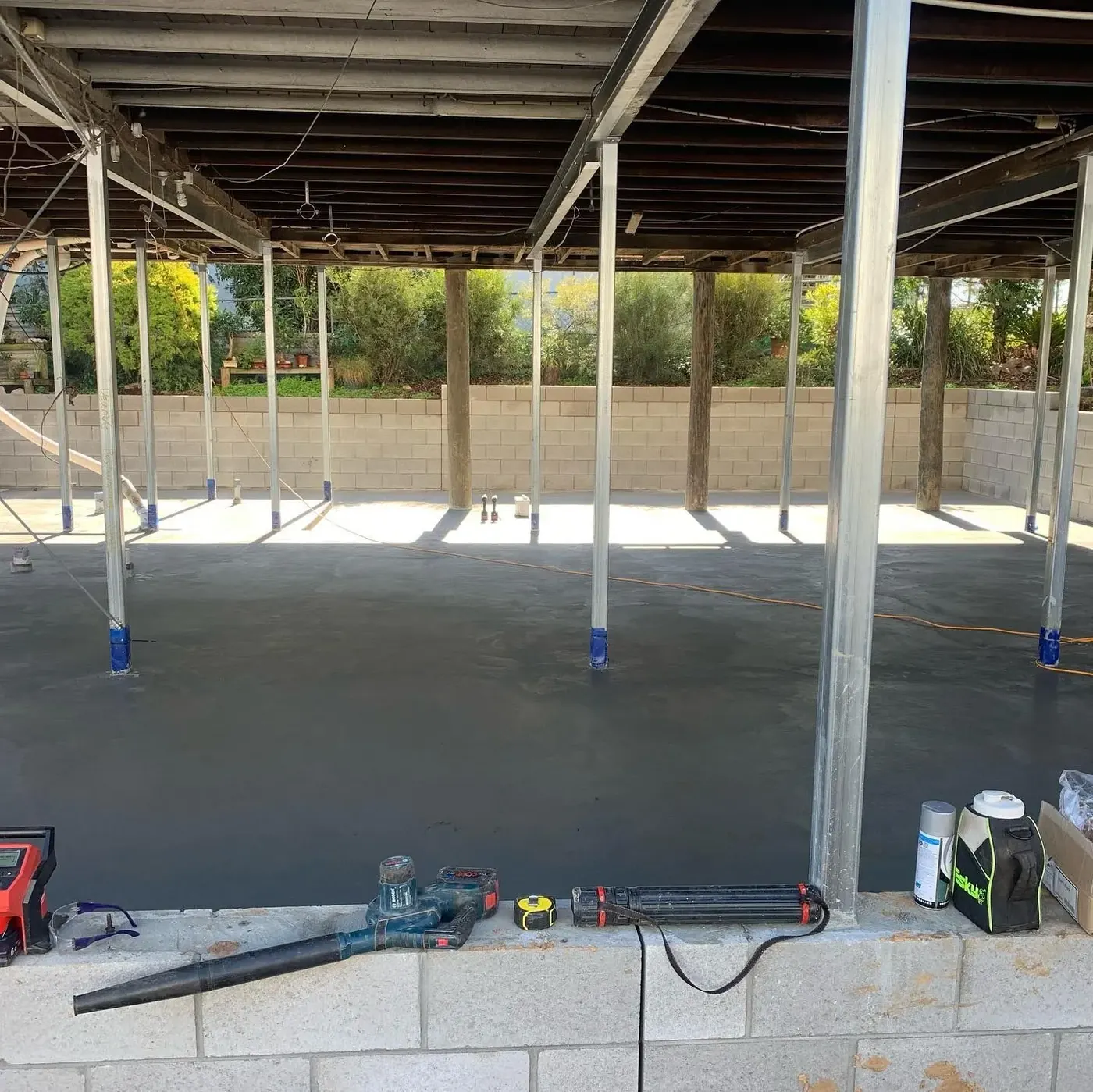 Underside of a home showing new posts and concrete footings