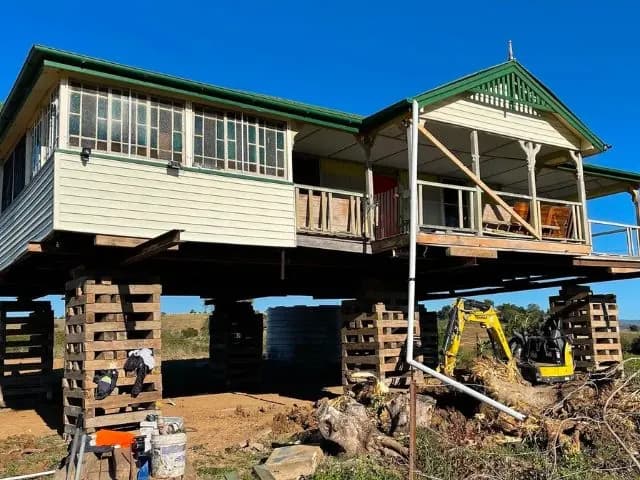 House on jacks with an excavator working alongside during a restump