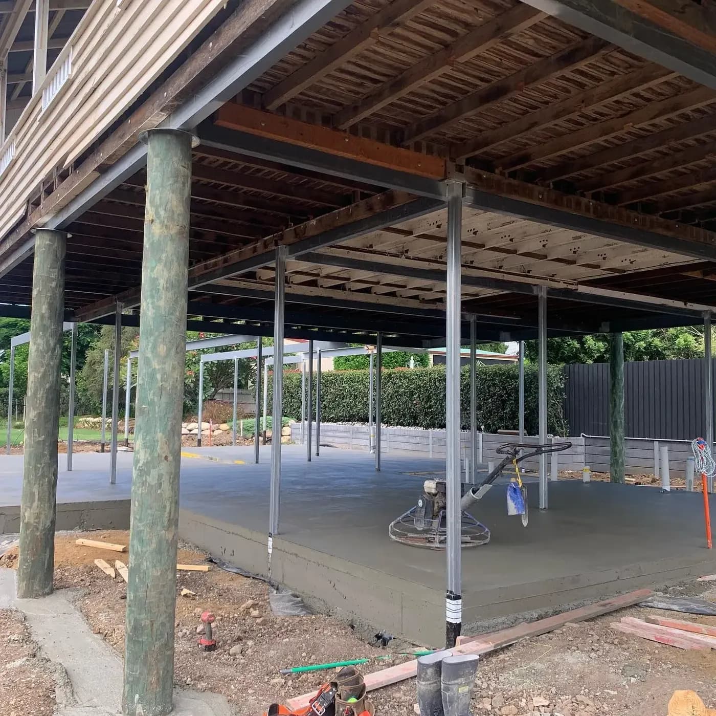 Underside of a raised house with a newly poured concrete slab