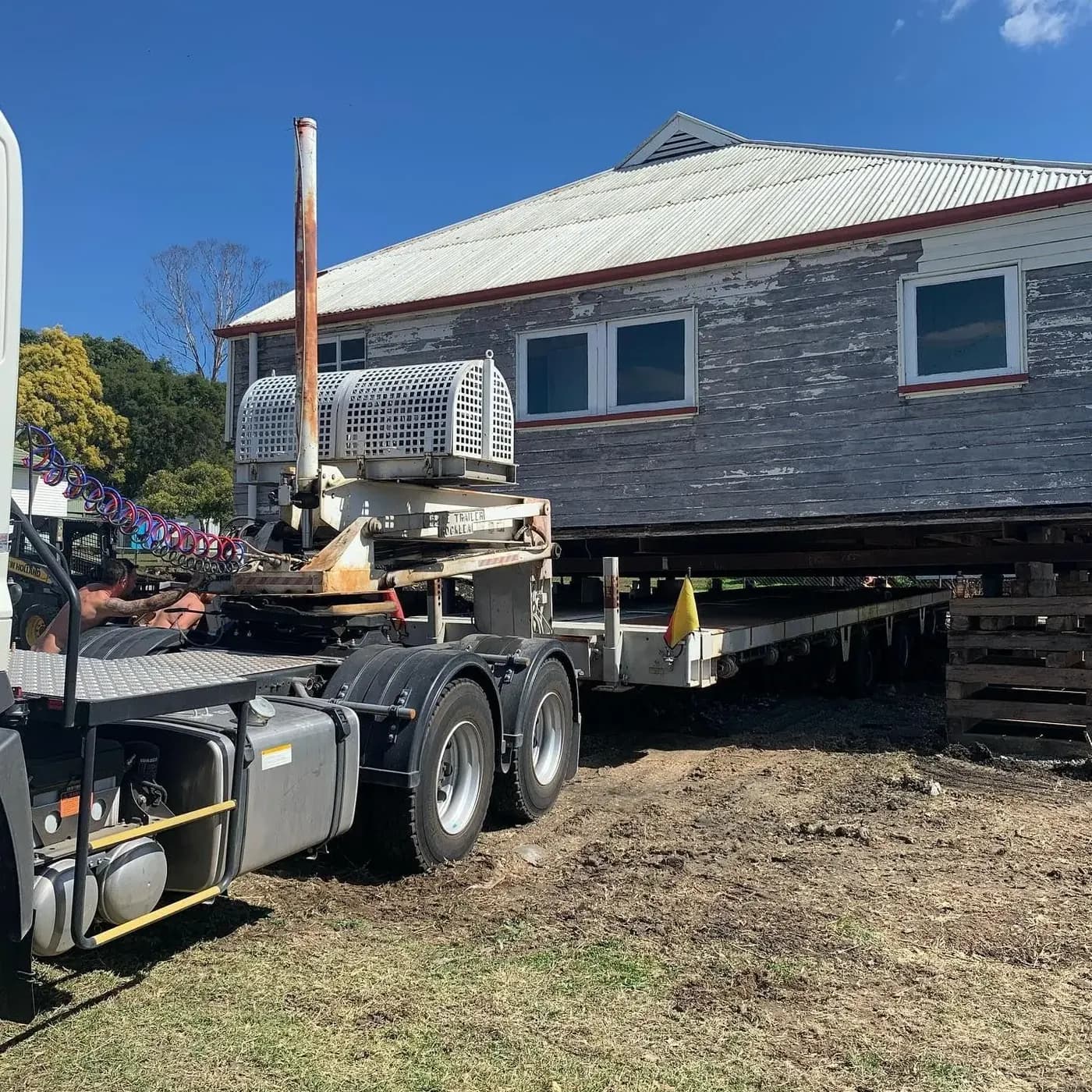 House loaded on a low-loader trailer ready for relocation